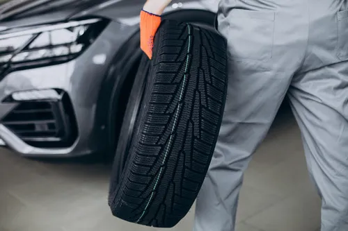 Tyre fitter holding a new tyre